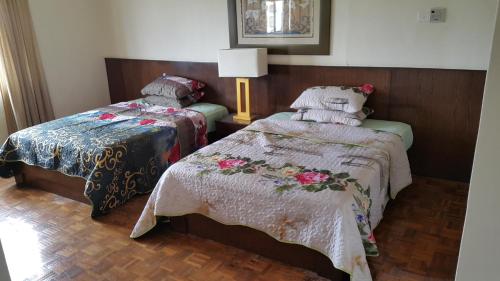 um quarto com 2 camas e um candeeiro em Famosa D Savoy 3-Bedroom Condo in Alor Gajah em Malaca