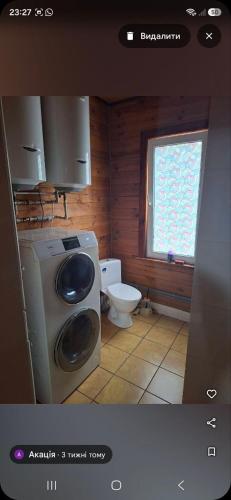 a bathroom with a washing machine and a toilet at Akacia in Svityazʼ