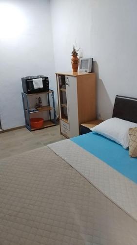 a bedroom with a bed and a desk with a laptop at Nada Rooms in Budva