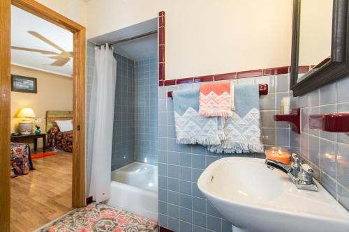 baño de azulejos azules con lavabo y bañera en The Wisconsin Wood Inn en Dickeyville