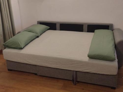a bed with two green pillows on top of it at Loft in a quiet condominium in Vitry-sur-Seine