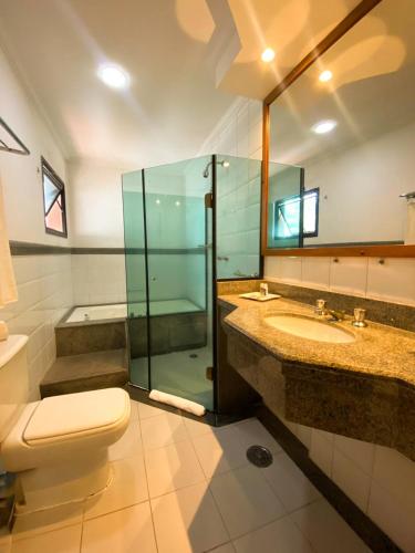a bathroom with a toilet and a sink and a shower at Summit Suites Jundiai in Jundiaí