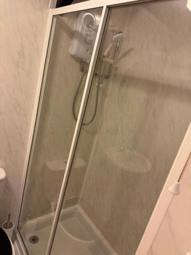 a shower with a glass door in a bathroom at The Loft in Nantgaredig