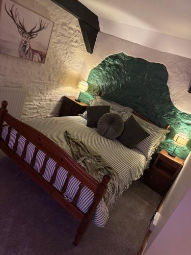 a bedroom with a large bed with a green headboard at The Loft in Nantgaredig