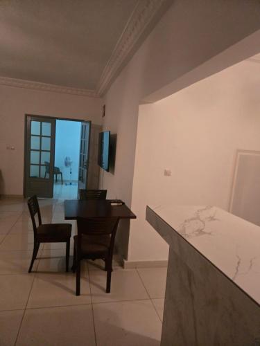 a living room with a table and chairs and a kitchen at Le gite 1 in Libreville