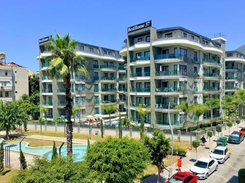 a large apartment building with a pool and palm trees at SA Apartments! Luxury Residence with Private Beach in Alanya