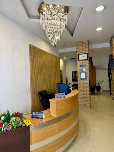 a lobby with a reception desk and a chandelier at Living Montes in Medellín