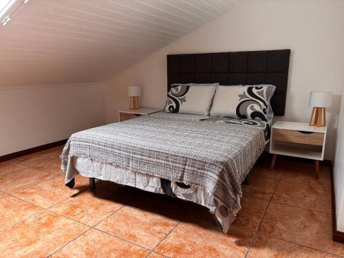 a bedroom with a large bed and two night stands at Tina's Place in Machico