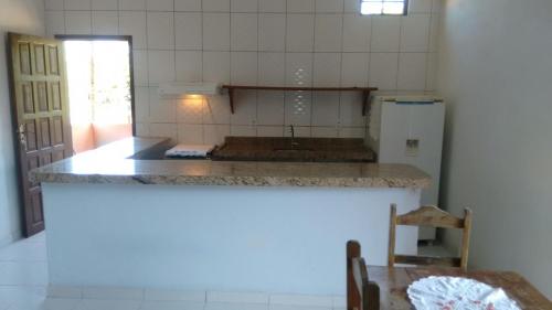 a kitchen with a counter top and a refrigerator at Trancoso Casas Para Temporada in Trancoso