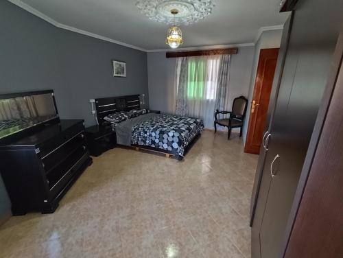 a bedroom with a bed and a dresser at La Luna Rentals in Asilah