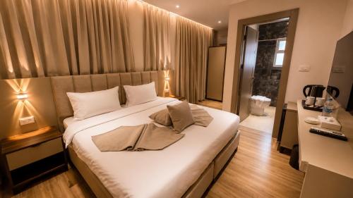 a bedroom with a large bed with white sheets at Sama Al Sweifieh - سما الصويفية in Amman