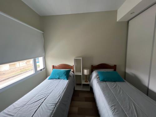 two beds in a small room with a window at Coty A in Saladillo