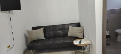 a black couch in a room with a table at Lopofa in Lunca de Sus
