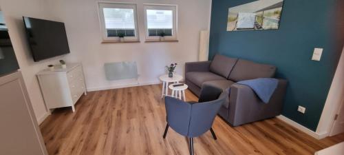 a living room with a couch and a tv at Ferienhaus Wellenklang in Glowe