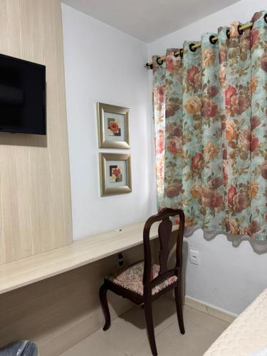 a chair sitting in a room with a television at Hotel Guerra - Pousada Montebelo in Jaguaruna