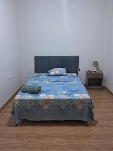 ein Schlafzimmer mit einem Bett mit blauer Bettdecke in der Unterkunft Edificio Las Palmas in Tumbes