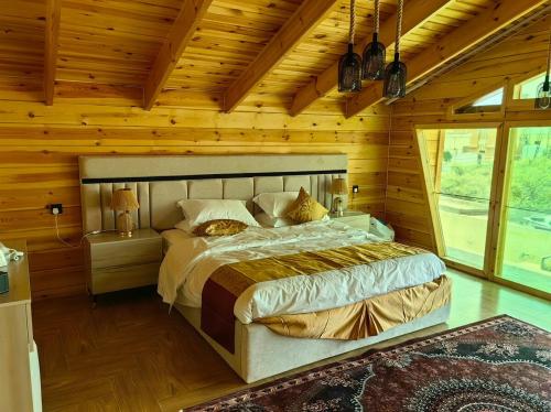 a bedroom with a large bed in a wooden room at اكواخ لاكجري ابها 2 in Abha