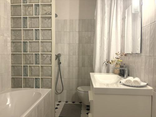 a bathroom with a tub and a sink and a toilet at Central Park View Apartment in Dobrich
