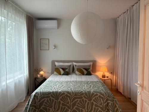 a bedroom with a bed and a large window at Central Park View Apartment in Dobrich
