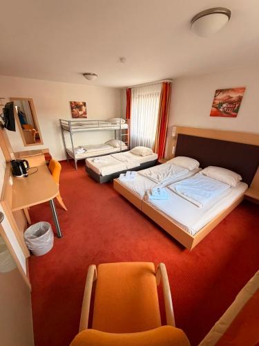 a hotel room with two beds and two chairs at Hotel Allee 25 in Stuttgart