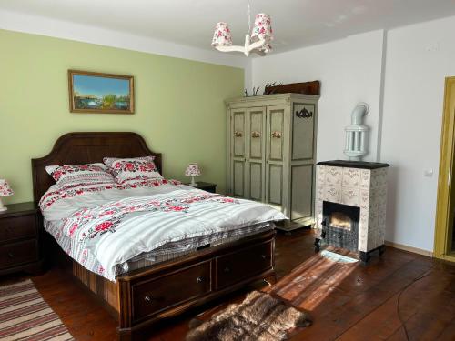 a bedroom with a bed and a fireplace at La Nea Traian in Vama Buzăului