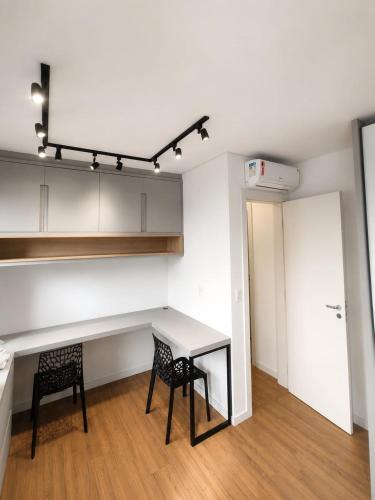 a kitchen with a table and two chairs at Apt Premium com Vista Panorâmica e Lazer Completo in Joinville