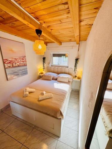 a bedroom with a bed and a wooden ceiling at Villa Silent Bay Lučice in Milna