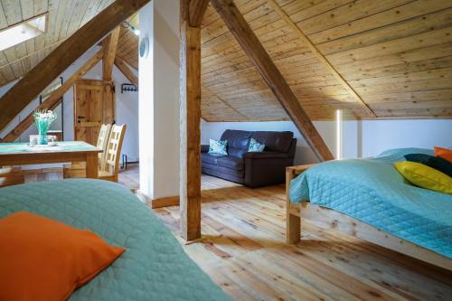 a bedroom with a bed and a couch in a room at Lawki Booking-Na Strychu in Ławki