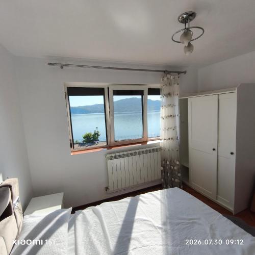 a bedroom with a bed and two windows at Apartament -BeaSarah-Orsova in Orşova