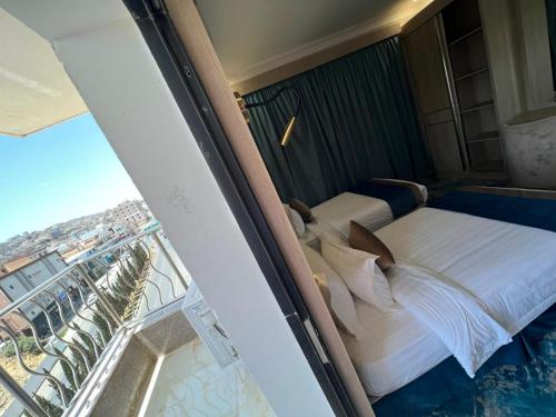 a hotel room with a bed and a balcony at The High View Hotel - ذا هاي فيو in Al Baha