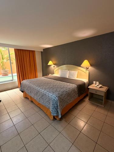 a hotel room with a bed and a window at Plaza Inn Express in Tapachula