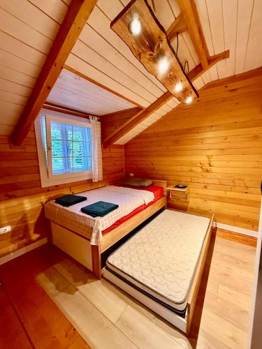 a bedroom with two beds in a wooden cabin at Villa Kadeli 
