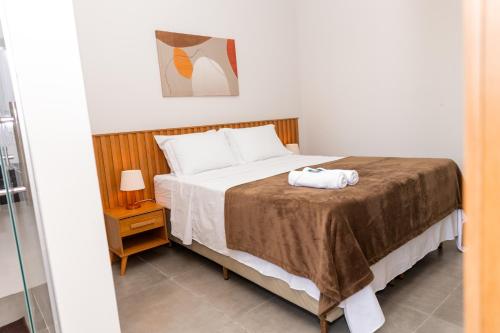 a bedroom with a bed with a towel on it at Lagoa Suítes in Lagoa Santa