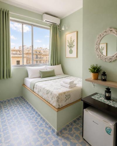 a small bedroom with a bed and a window at Acropolis Center Rooms in Athens