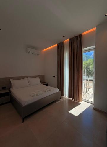 a bedroom with a large bed and a large window at RiverMount Hotel Borsh in Borsh