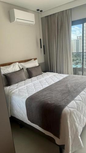 a bedroom with a large bed with a window at GAV Beach Resort - Smart in Salinópolis