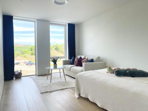 a white bedroom with a bed and a couch at Bryggebyen in Arendal