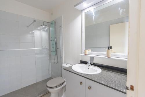 a white bathroom with a sink and a toilet at Studio équipé,Terrasse,Marina & plage à pied in Saint-François