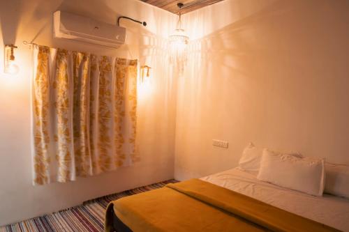 a small bedroom with a bed and a window at Jambhul Nest studio Pool & Rainforest Escape in Dhamni