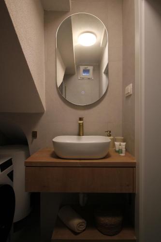 a bathroom with a white sink and a mirror at Almara stone house - Authentic stone house in Vis in Vis