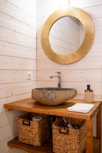 a bathroom with a stone sink and a mirror at Cabane La Douce Parenthèse - Spa & Sauna in Brive-la-Gaillarde