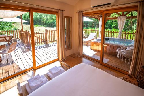 a room with a view of a deck with a hot tub at Cabane La Douce Parenthèse - Spa & Sauna in Brive-la-Gaillarde