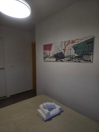 a room with a bed with a picture on the wall at La Tortuga Lodging RoomS in Tarifa