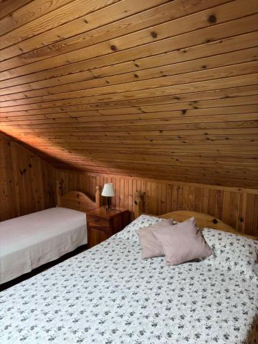 a bedroom with two beds and a wooden ceiling at Brvnara Nenadić in Užice