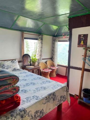 a bedroom with a bed and chairs in a boat at Prathmesh Homestay in Bijanbāri Bāzār