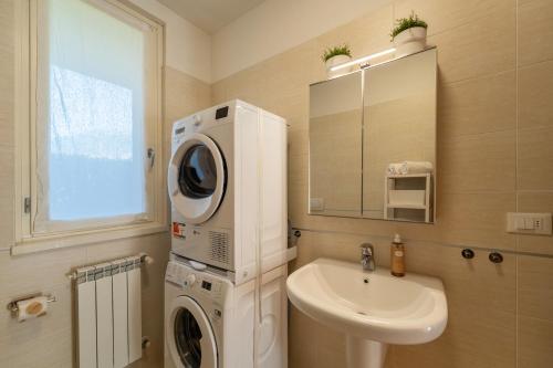 a bathroom with a washing machine and a sink at Bellagio Breva in Bellagio