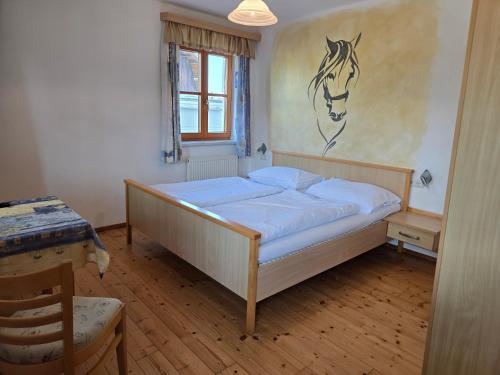 a bedroom with a bed with a horse on the wall at Reitpark Gstöttner in Schönau im Mühlkreis
