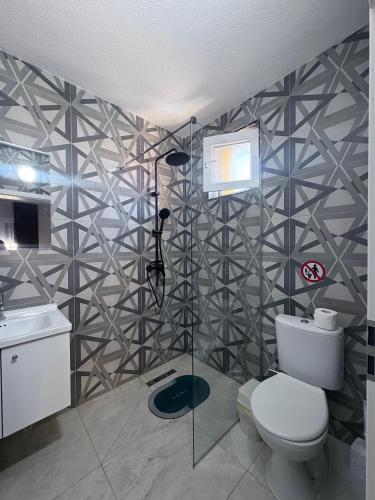 a bathroom with a shower and a toilet and a sink at Hotel AKSA in Prizren