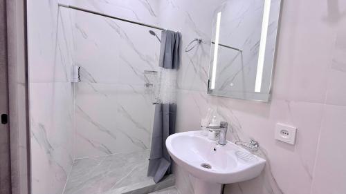 a white bathroom with a sink and a shower at Zvartnoc siti star in Pʼarakʼar