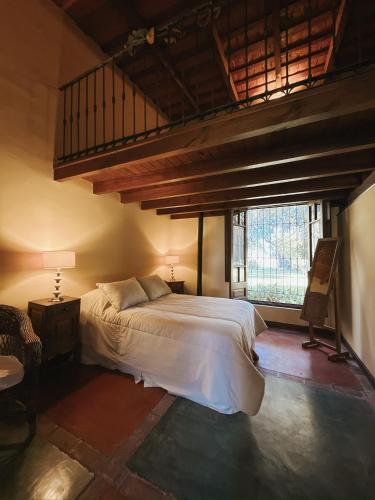 a bedroom with a bed and a large window at Hostería Rural Les Aldudes in San Andrés de Giles